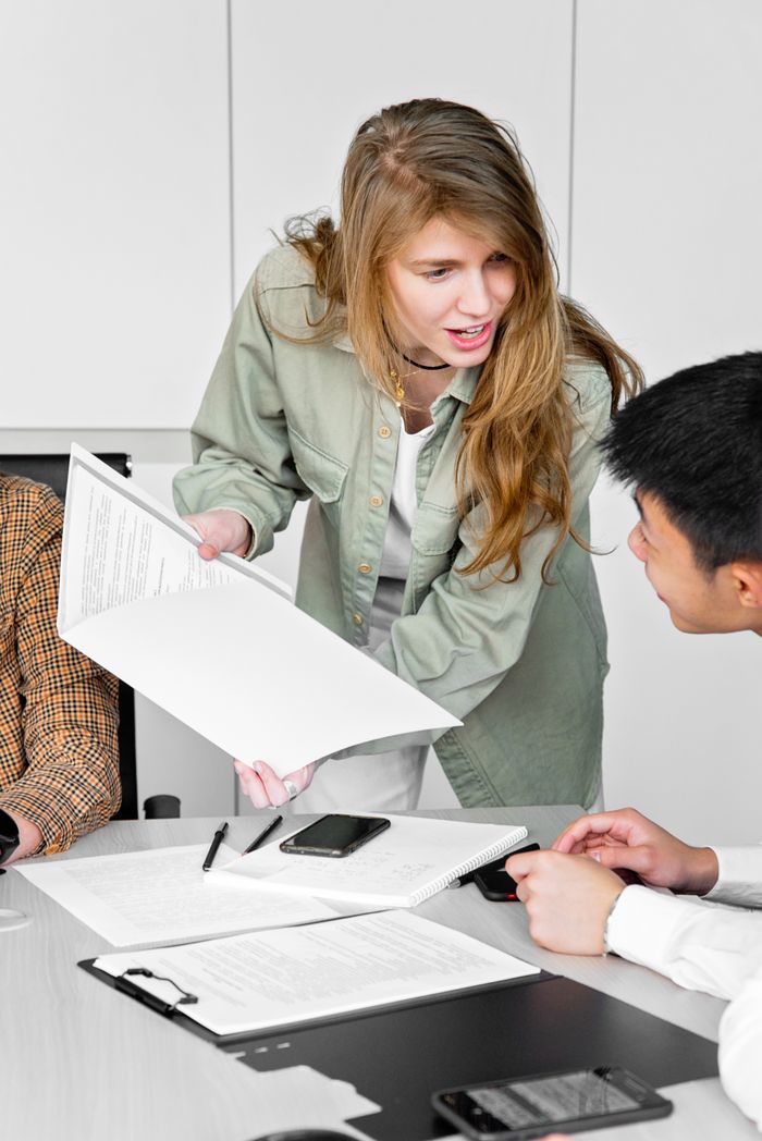 Colleagues in a modern office discussing documents and ideas collaboratively.